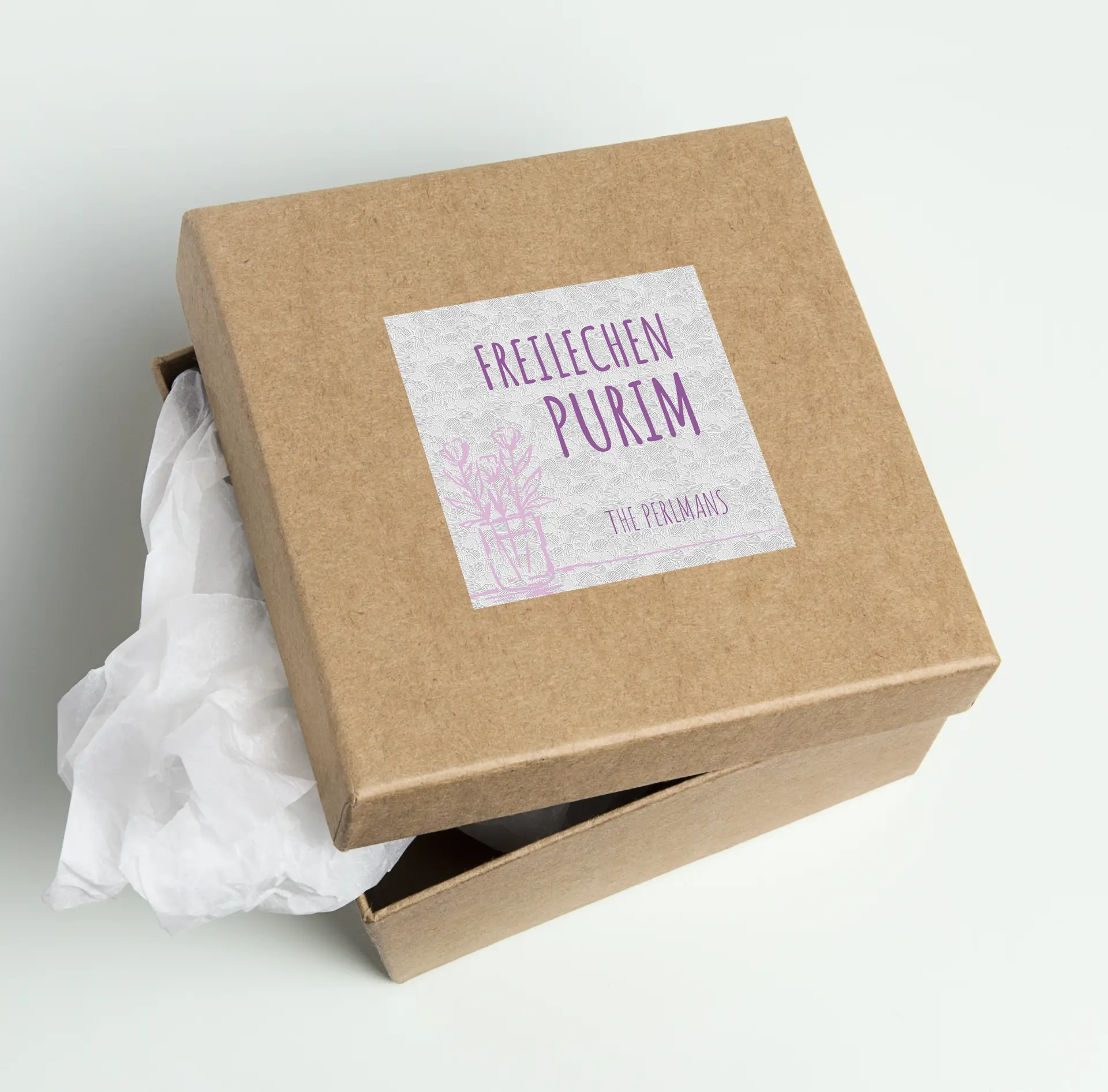 Elegant purple Freilechen Purim label applied to a kraft gift box